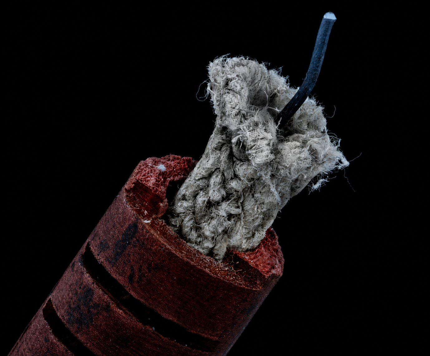 Avkapad rör-/kabelände med frilagd grå asbestliknande fiber